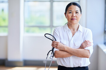 Confident Female Doctor Standing with Stethoscope In Bright Office Space