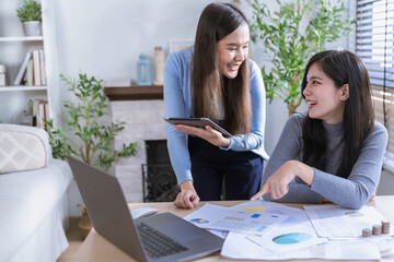 Team of partners  Asian business woman discussing project on laptop sitting at table in office. Two...