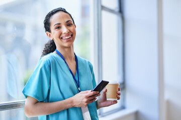 Smiling Nurse Taking a Break with Coffee and Smartphone in Hospital