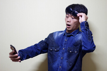 Surprised Man with Sunglasses Takes a Selfie Capturing Shock and Delight