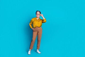 Full length photo of confident attractive lady dressed shirt glasses smiling emtpy space isolated blue color background