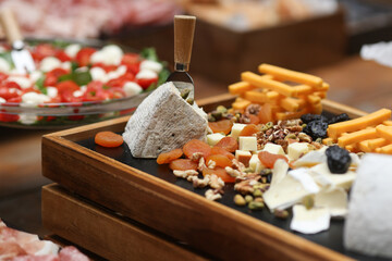 Shallow depth of field (selective focus) details with various types of cheese at a buffet.