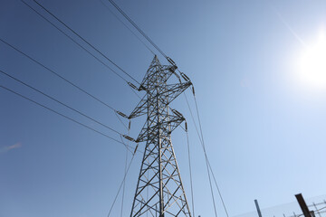Black and white image with a high voltage electrical pole.