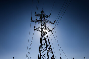 Black and white image with a high voltage electrical pole.