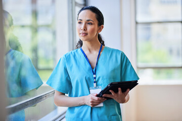 Professional Female Nurse in Scrubs with Digital Tablet at Hospital