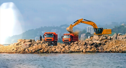 Breakwater construction on sea coastline. Excavator pushes stones © Terri_Crozier 