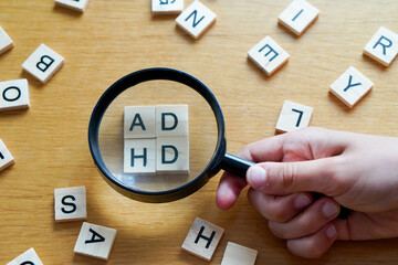 magnifying glass with wooden letters ADHD attention deficit hyperactivity disorder, learning disability