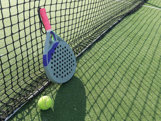 paddle tennis racket and balls on court 