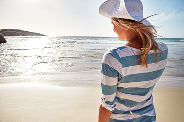 Woman, back and beach with hat for holiday, fun and break as tourist in Florida. Female person,...
