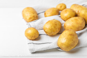 Young potatoes. Fresh potatoes  on a wooden background.Harvesting collection. organic, freshly dug potatoes. Agricultural background. Vegan. Vegetables.Place for text.Copy space