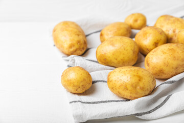 Young potatoes. Fresh potatoes  on a wooden background.Harvesting collection. organic, freshly dug potatoes. Agricultural background. Vegan. Vegetables.Place for text.Copy space