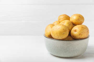 Young potatoes. Fresh potatoes  on a wooden background.Harvesting collection. organic, freshly dug potatoes. Agricultural background. Vegan. Vegetables.Place for text.Copy space