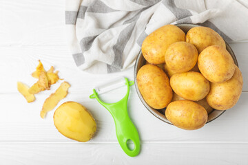 Young potatoes. Raw potatoes and knife on a wooden background.Peel potatoes.Harvesting collection. organic, freshly dug potatoes. Agricultural background. Vegan. Vegetables.Place for text.Copy space
