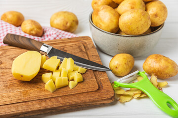 Young potatoes. Raw potatoes and knife on a wooden background.Peel potatoes.Harvesting collection. organic, freshly dug potatoes. Agricultural background. Vegan. Vegetables.Place for text.Copy space