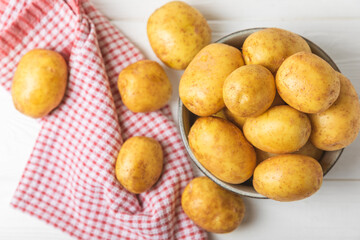 Young potatoes. Fresh potatoes  on a wooden background.Harvesting collection. organic, freshly dug potatoes. Agricultural background. Vegan. Vegetables.Place for text.Copy space