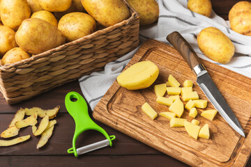 Young potatoes. Raw potatoes and knife on a wooden background.Peel potatoes.Harvesting collection. organic, freshly dug potatoes. Agricultural background. Vegan. Vegetables.Place for text.Copy space