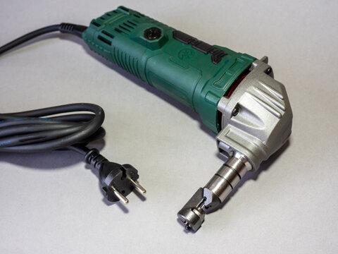 Nibbler for precise cutting of metal and other sheet materials. Electric tool for clean straight and curved cuts with low material wastage. Metal cutter