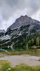 Alpine mountain landscape in spring with Sebensee lake and snowy Sonnenspitze peak in the background