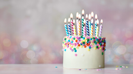 Colorful celebration birthday cake with colorful birthday candles and sugar sprinkles