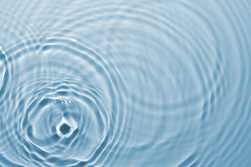 Rippled surface of clear water on light blue background, top view