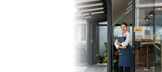 A woman in a blue apron stands outside a store with a laptop in her hand