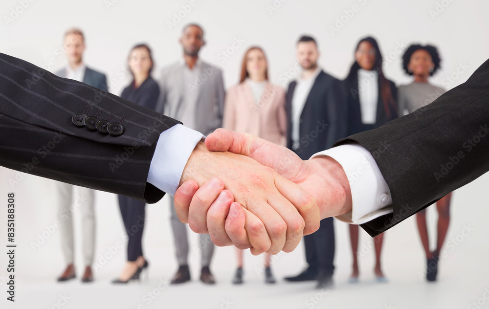 Poster two businesspeople shaking hands with a group of diverse professionals in the background, conveying 