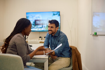 Happy colleagues analyzing business reports in creative office.