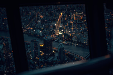 Tokyo at night seen through a window of a high tower