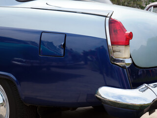 Close-up of the back side of a beautiful blue classic car.