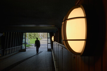 Exit from a pedestrian underpass in the Finnish town of Kerava: lamp on the wall, silhouette of a...