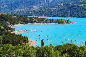 Naklejka premium Bay of Saint Michel on the north shore of the lake of Serre-Ponçon in the French Alps, a dammed artificial reservoir gathering the water of the Durance river