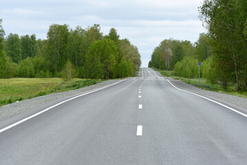 High-speed asphalt road in the spring forest. Country road.