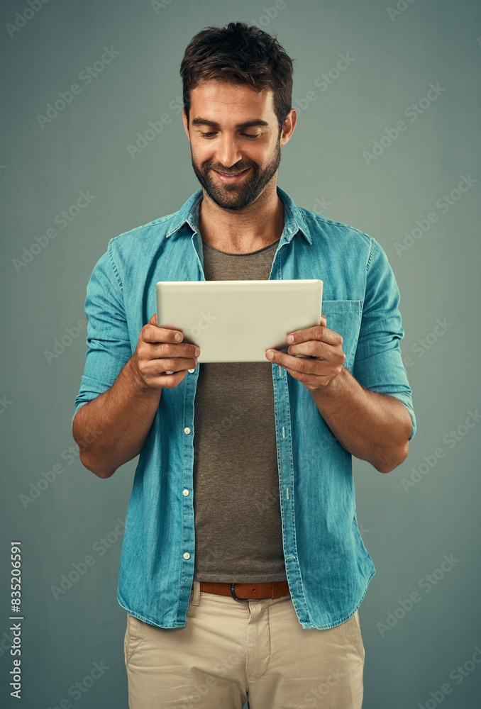 Poster Man, studio and checking with tablet and smile, career with software programming in London. Male creative, ebook and gray background with happiness for digital job, mobile app or website development