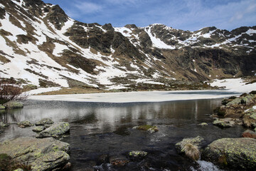 Un lago medio helado rodeado de montañas en otoño
