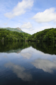 Un lago precioso entre monta&ntilde;as con reflejo en el agua de las nubes