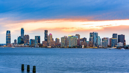 Naklejka premium Jersey City panorama at dusk as viewed from Pier 57, New York City, across the Hudson River