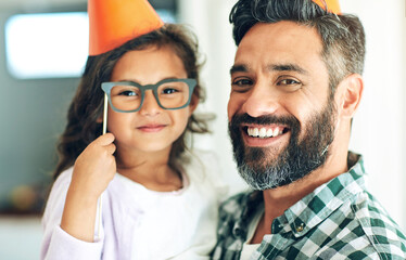 Father, girl and portrait with birthday hats for celebration with eyeglasses, happy and props for decoration in home. Family, child and dad at party event with smile for bonding and social gathering