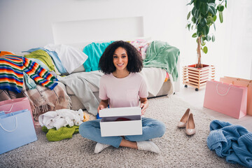 Photo of lovely positive cute girl wearing trendy clothes sitting carpet organizing purchase...