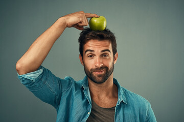 Man, portrait and balance apple on head for healthy diet, wellness and natural organic food...