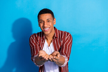 Photo of good mood friendly guy wear striped stylish shirt over white t-shirt palms demonstrate...