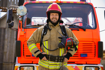 Portrait of firefighter in uniform near fire truck outdoors