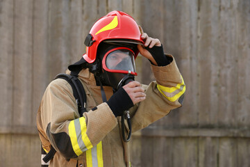 Firefighter in uniform wearing helmet and mask outdoors