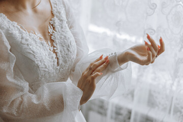 A woman in a white dress is putting on her wedding ring. Concept of love and commitment, as the...