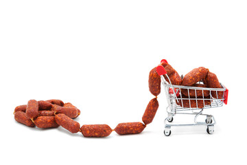 Shopping supermarket cart with dry-cured sausages and a pile isolated on a white background....