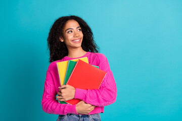 Photo portrait of attractive teen girl hold copybooks look empty space dressed stylish pink clothes isolated on aquamarine color background