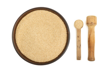 Amaranth cereals in a ceramic bowl and wooden spoons on a white background