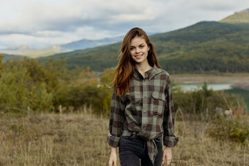 A woman in casual plaid shirt and jeans enjoying serene mountain lake view in nature travel scene