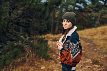 A young woman enjoying the tranquility of nature in a knitted sweater and beanie amidst the forest...