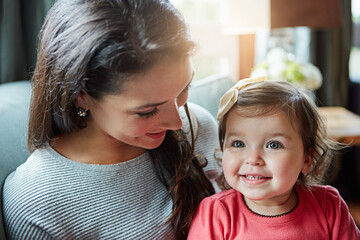 Mother, child and relax or smile on sofa with resting, bonding and love with embrace or fun together. Family, woman and daughter or kid with happy for trust, care or security in living room of home