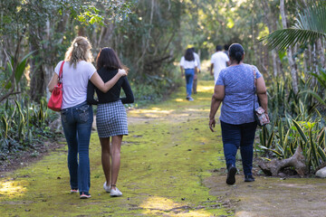 Fototapeta premium women walking on a trail in the jungle, co-living outdoors, hiking